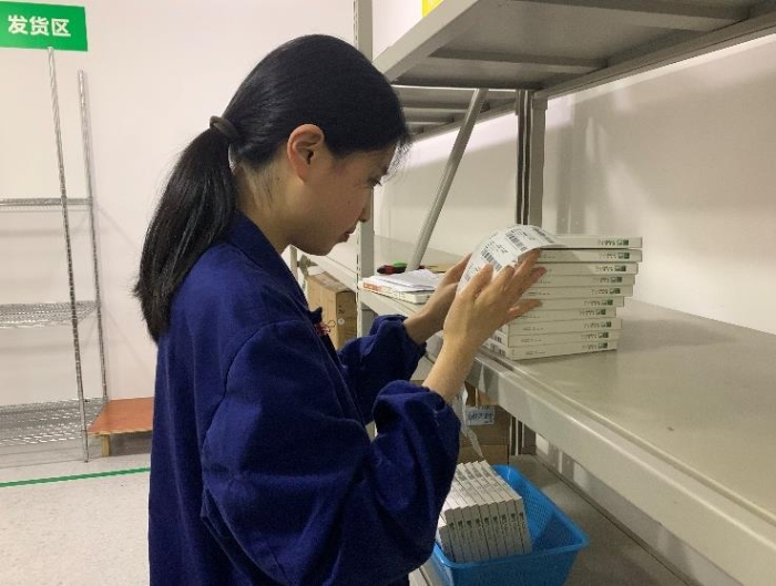 圖為金華市中心醫院工作人員將追溯二維碼粘貼到醫療器械包裝盒上。何璇 攝