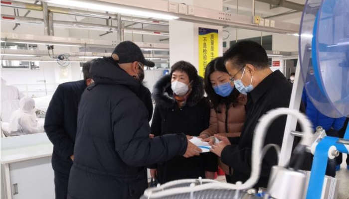 李璐（右二）督導期間聽取煙臺舒朗公司負責人醫用防護服改進設計的介紹。