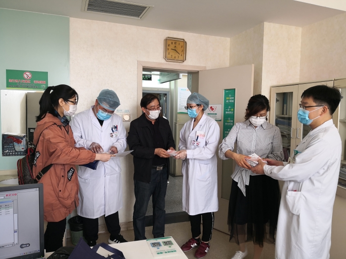 工作人員向醫護人員贈送化妝品安全科普宣傳手冊