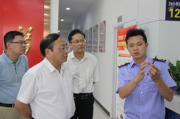 上官新晨（左二）在鷹潭市局東湖分局觀看基層執法人員演示如何運用智慧市場監管網格化管理平臺開展監督檢查工作等情況。