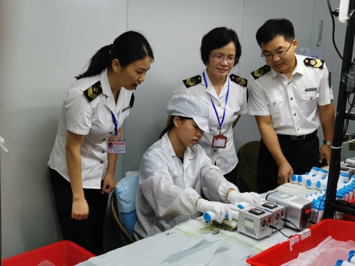 工作人員在檢查紅外體溫計、口罩生產企業。