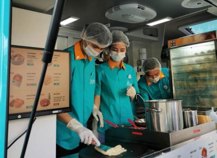 “逸小兔”流動早餐車的店員正在為顧客備餐。新華網發（熊多多 攝）