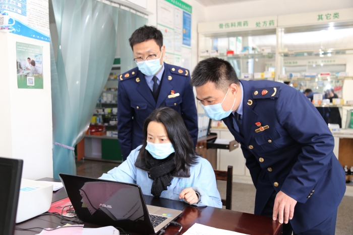 圖為執(zhí)法人員在查看進(jìn)貨臺賬