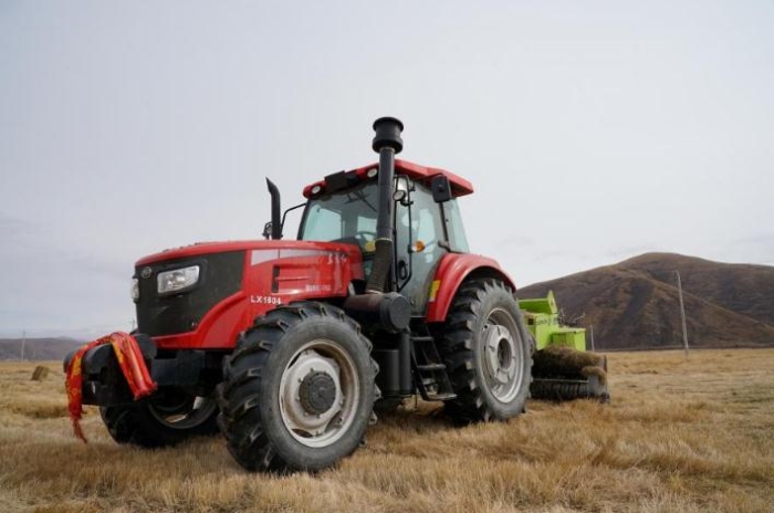 在青海省果洛藏族自治州甘德縣江千鄉(xiāng)，一位牧民正在飼草基地駕駛打捆機(jī)工作。（2020年11月3日攝）。新華社記者陳凱 攝
