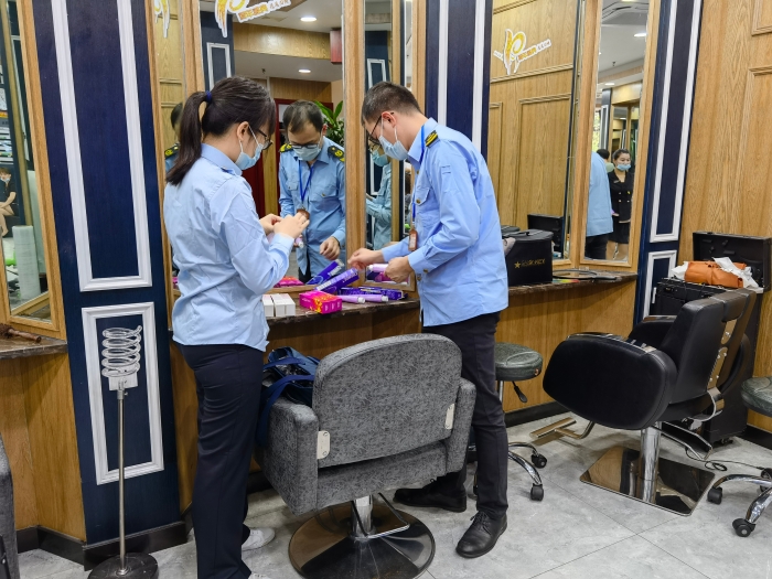 執法人員對青秀區美容美發機構的染發產品進行監督抽檢。