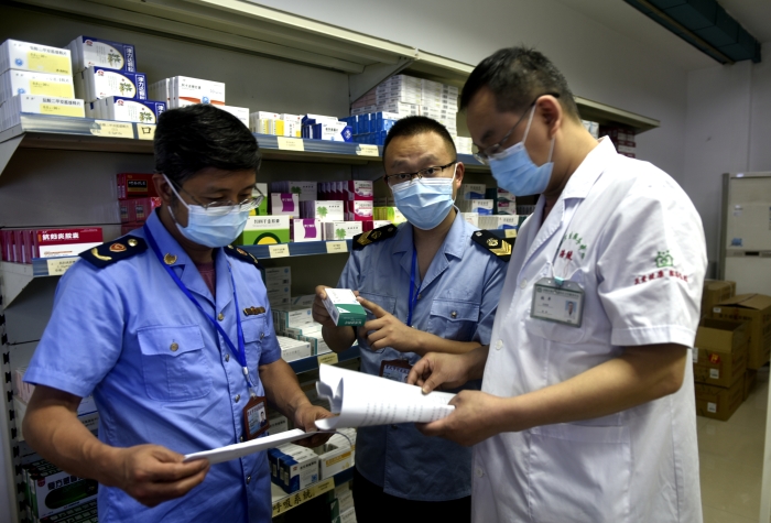 圖為執法人員按照“中選藥品”目錄抽取藥品抽檢樣本。