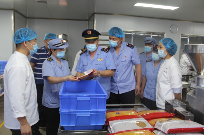 圖為執法人員在一家月餅加工廠檢查原料質量和進貨渠道。