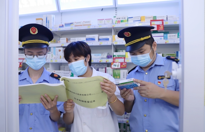 圖為9月13日執法人員在一家藥店查看網絡藥品銷售登記情況，并核對處方藥處方單。