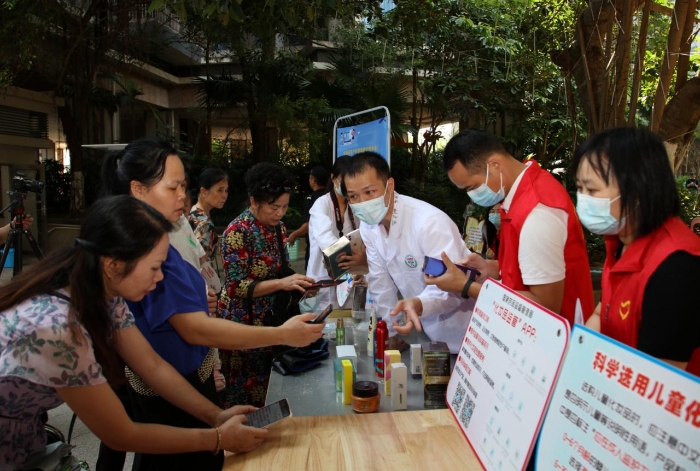 圖為社區(qū)群眾紛紛下載國(guó)家藥品監(jiān)督管理局“化妝品監(jiān)管”APP。（程奇攝）