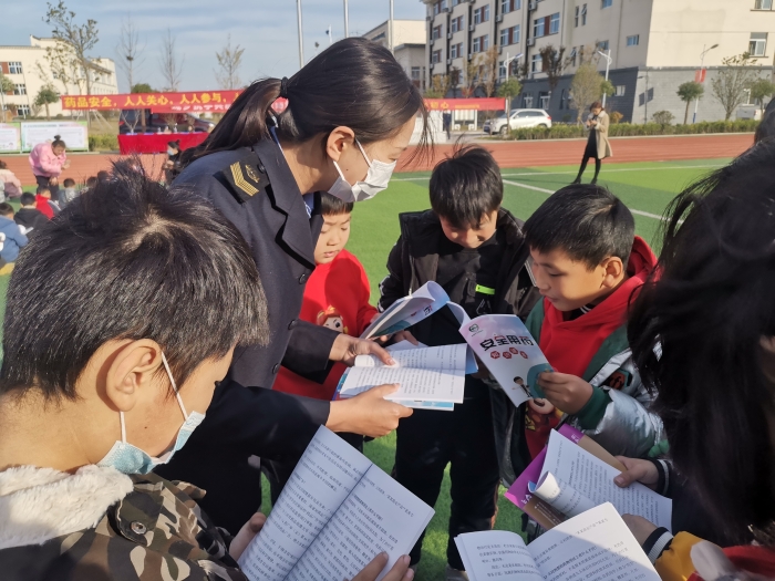 圖為工作人員為小學生講解安全用藥科普知識。