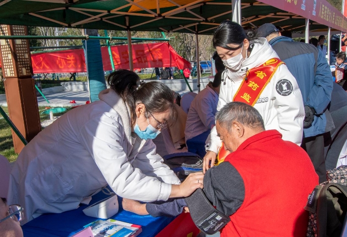 圖為醫護人員為群眾免費測量血壓并提供了健康用藥指導。