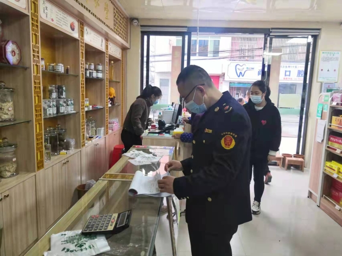 圖為執法人員在一家藥店查看登記臺賬。