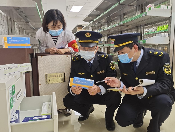 圖為2月12日該執(zhí)法人員正在一零售藥店檢查藥品
