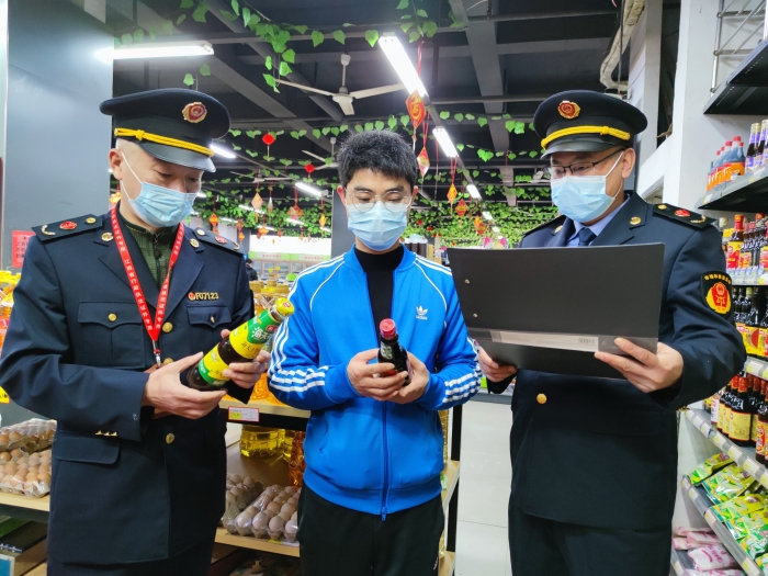 圖為執(zhí)法人員在一家超市檢查調(diào)味品質(zhì)量。