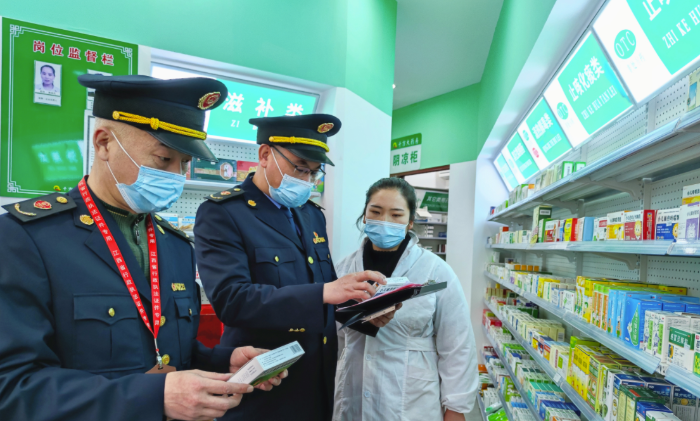 圖為執法人員檢查“四類藥品”銷售登記情況。