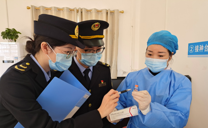 圖為執(zhí)法人員在一家醫(yī)院檢查新冠疫苗和抗原檢測試劑。