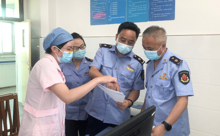 圖為城固縣市場監(jiān)管局執(zhí)法人員查驗疫苗、檢測試劑相關資質和冷鏈記錄。