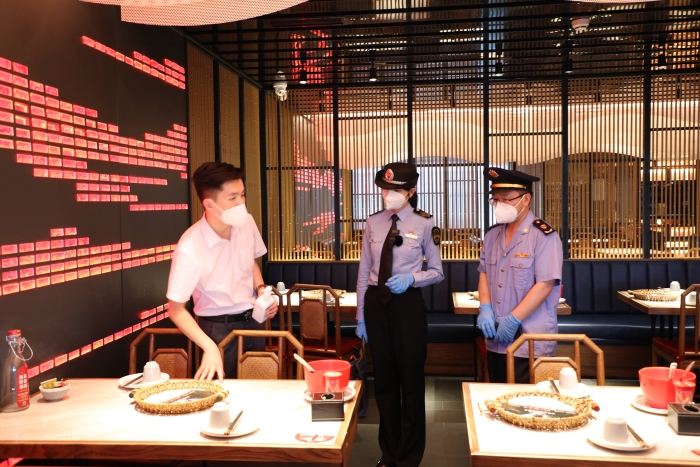 圖為海淀區市場監管局執法人員在現場檢查疫情防控及食品安全情況。