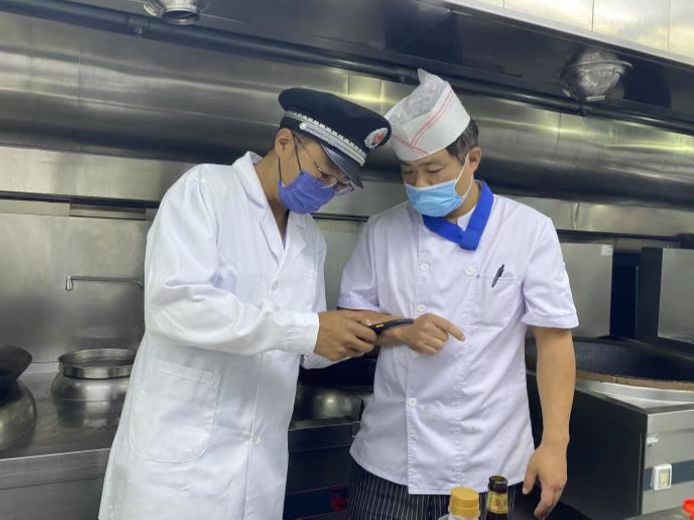 圖為海淀區市場監管局執法人員檢查學校食堂食品安全。