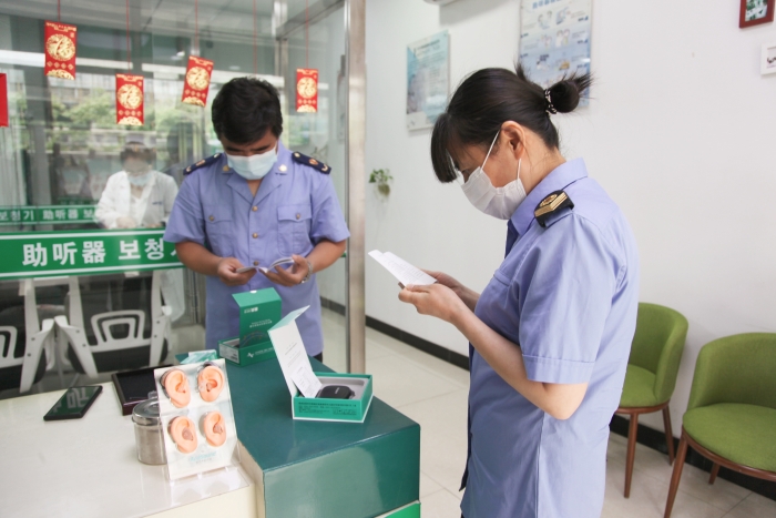圖為執(zhí)法人員檢查助聽器經(jīng)營企業(yè)產(chǎn)品質(zhì)量安全。