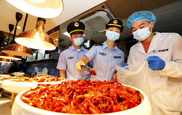 圖為8月2日，淮北市市場監督管理部門工作人員在夜市餐飲街區現場取樣。