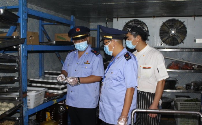 圖為該局執(zhí)法人員在一學(xué)校食堂檢查食品安全制度落實(shí)情況。