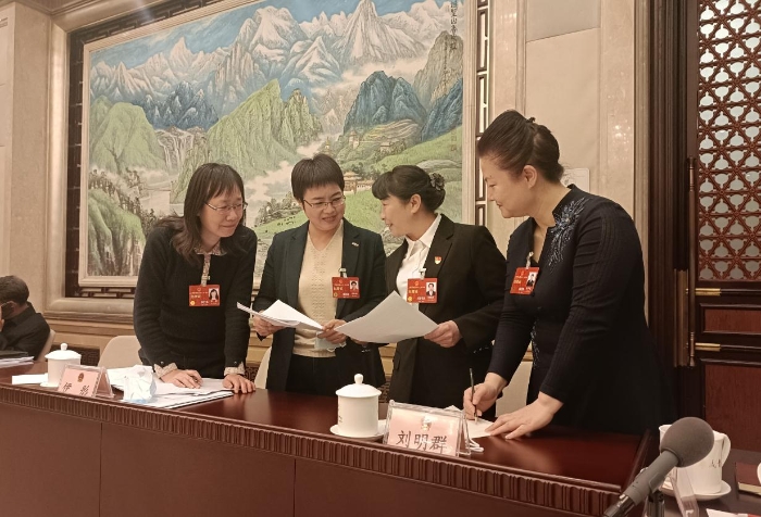 　　3月7日，十四屆全國人大一次會議北京代表團部分代表在小組會議結束后，繼續就關注的話題進行深入交流討論。（涂宣 攝）