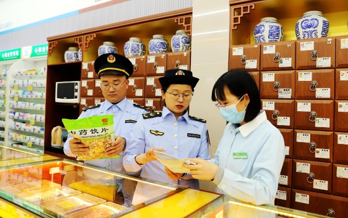 圖為4月25日，執法人員在對一家零售藥店的中藥飲片進行檢查。