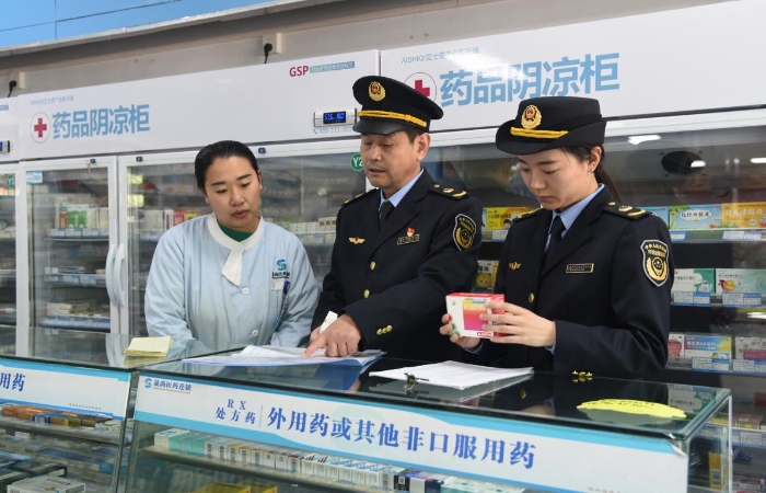 圖為執法人員在一家藥品經營企業檢查藥品采購和陰涼藥品儲存記錄情況。