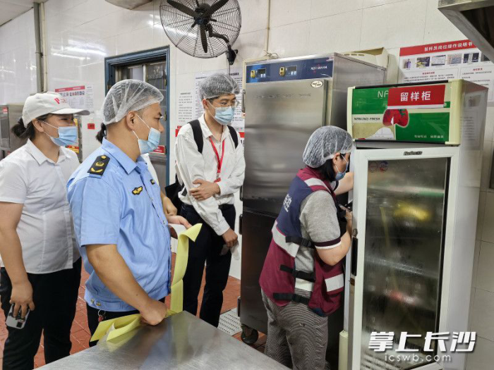 開福區市場監督管理局和區疾控中心等工作人員前往學校食堂，抽樣檢查了可疑的食品留樣和餐具。長沙晚報通訊員　黃勇軍　攝