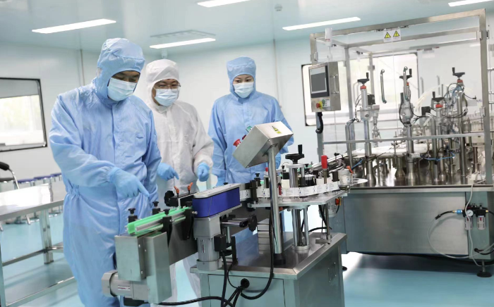 圖為執(zhí)法人員在一家醫(yī)療器械生產(chǎn)企業(yè)查看生產(chǎn)線情況。