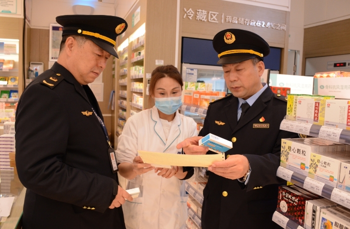 圖為執法人員在一家藥品經營企業檢查抗病毒藥品的購進情況。
